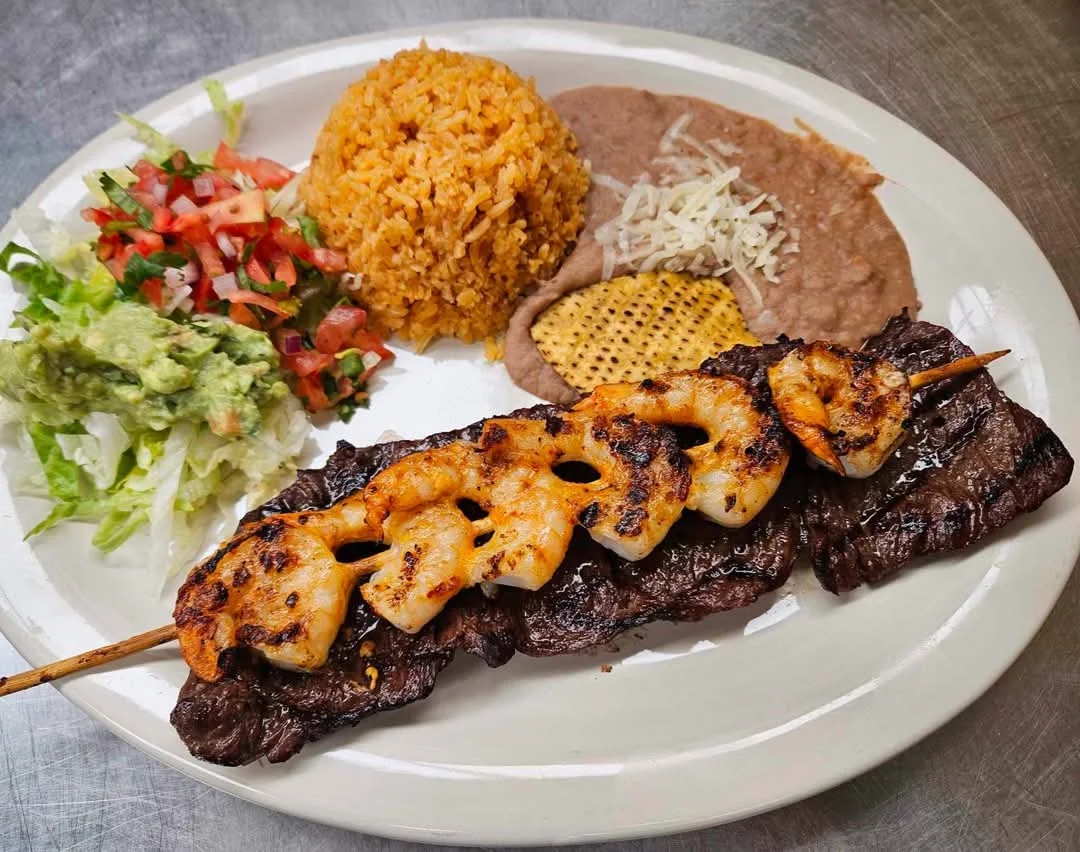 Grilled steak and shrimp with rice, beans, salad, and guacamole